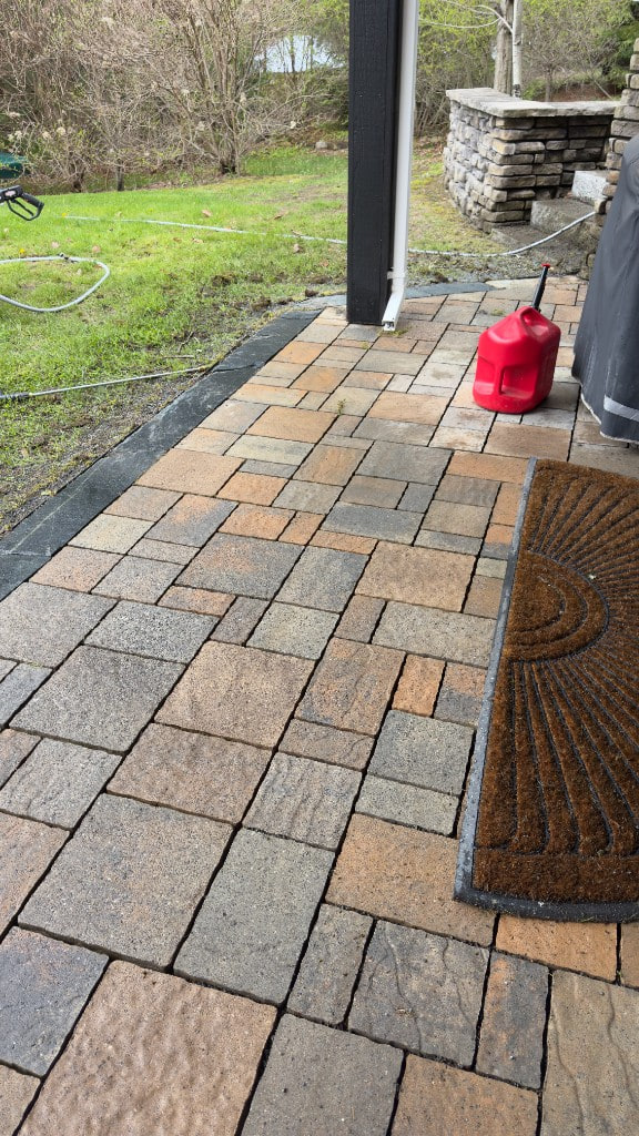 Stone patio edge beside a lawn during outdoor cleaning