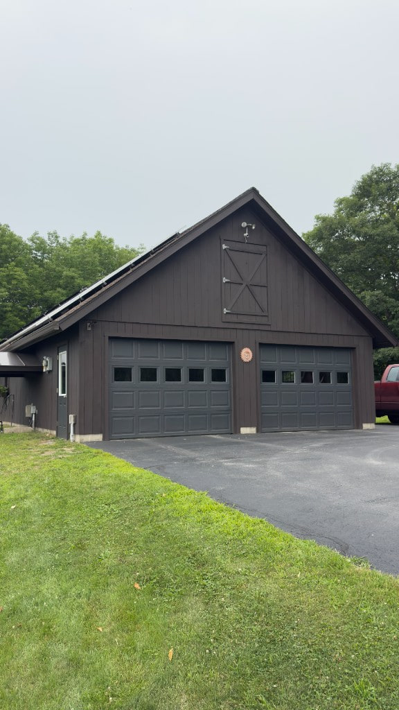 Dark brown barn-style garage after exterior painting