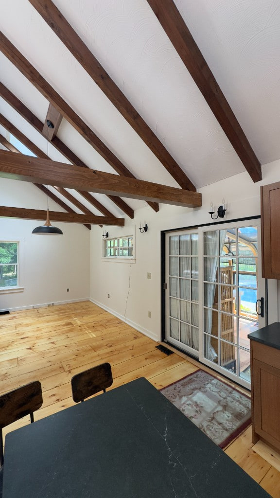 Open dining and kitchen space with vaulted beams and painted walls