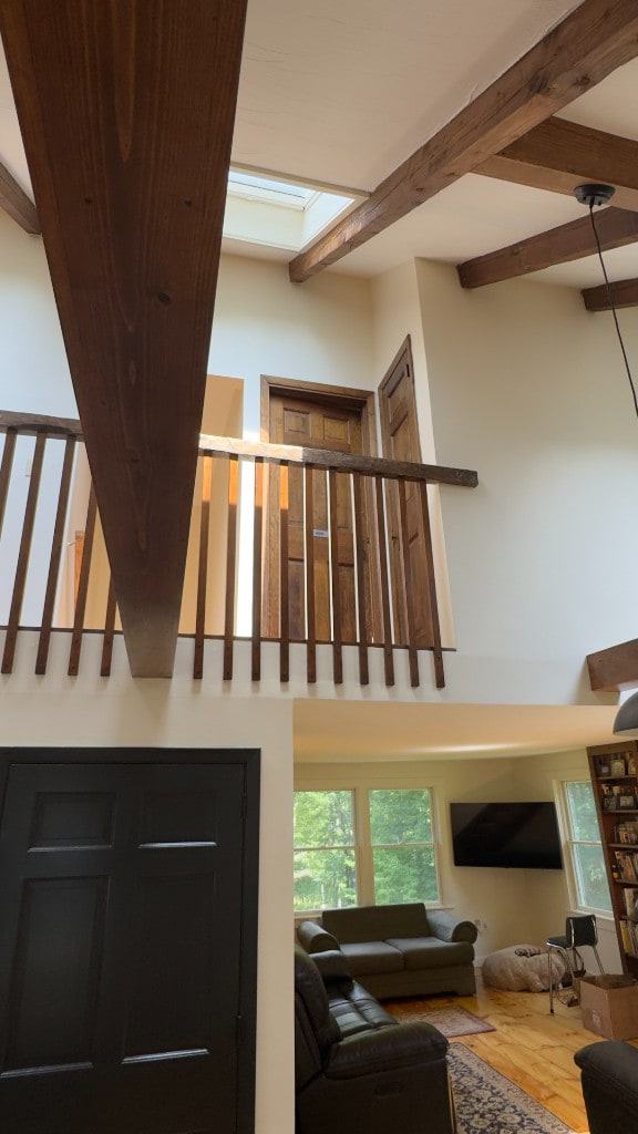 Double-height living area with loft railing and dark wood beams