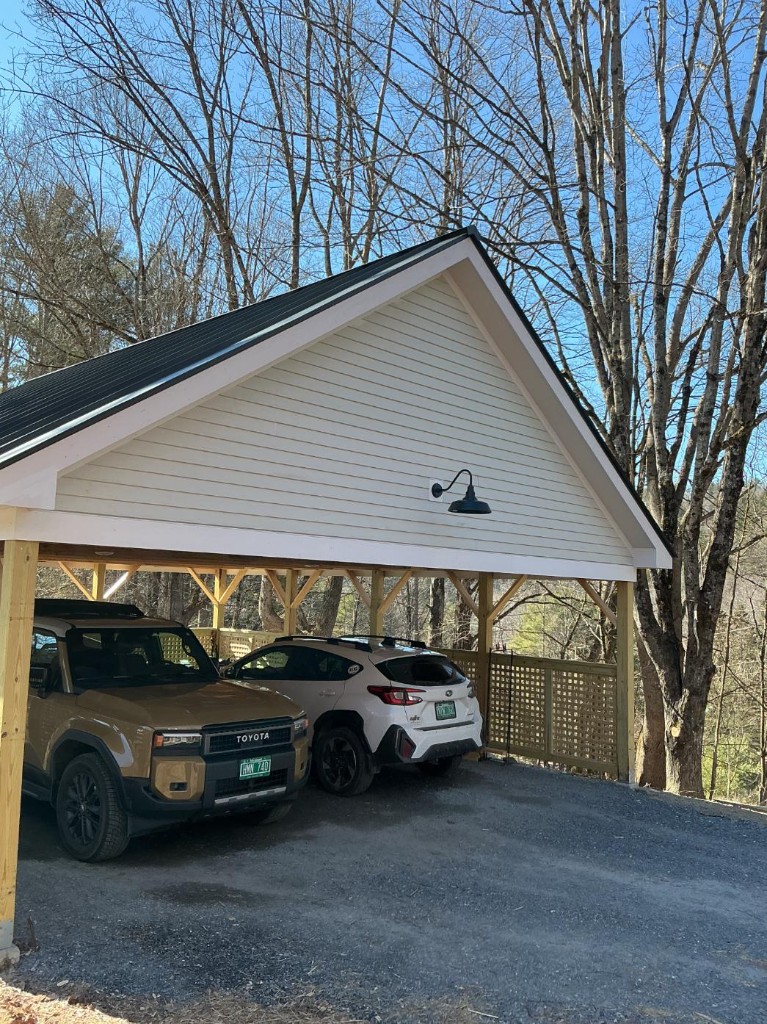 Carport with cream gable siding and white trim before exterior painting