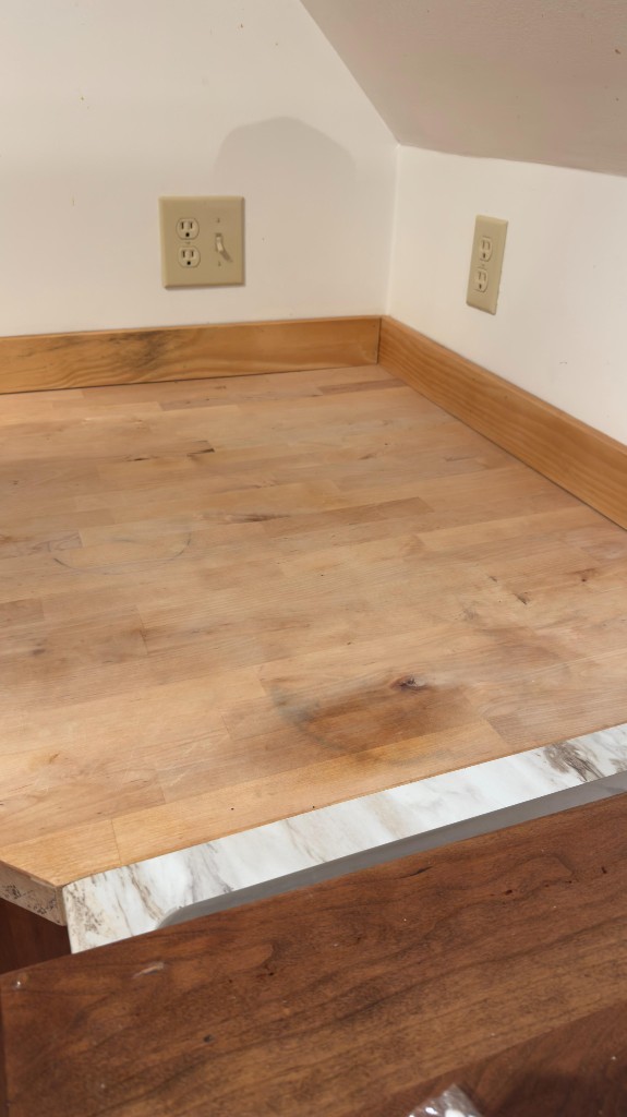 Worn butcher-block countertop corner before refinishing