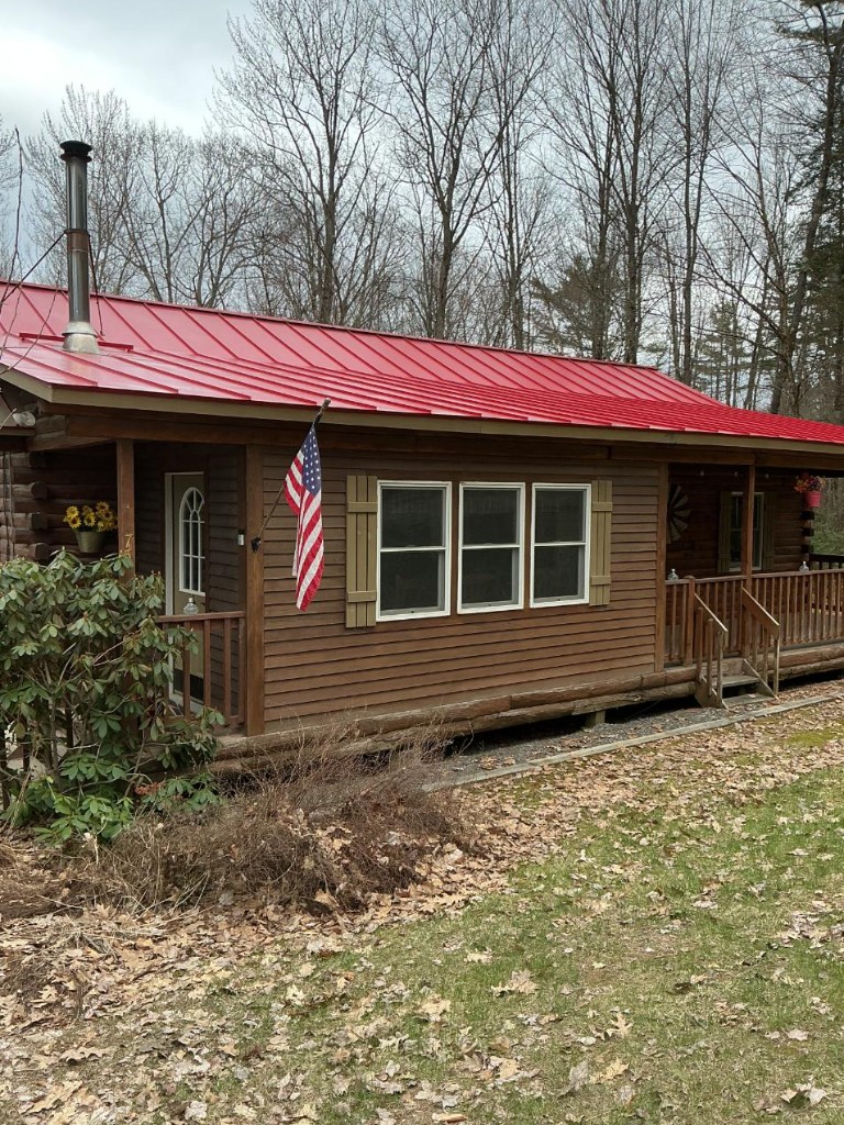 Cabin with standing-seam metal roof before roof coating