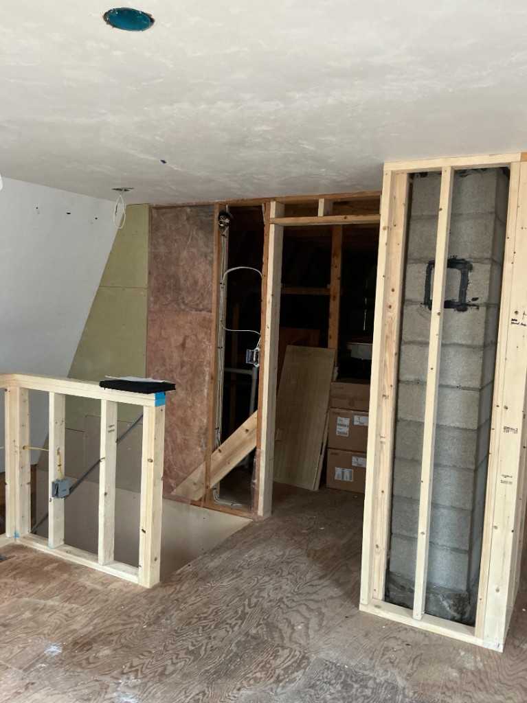 Unfinished loft landing with exposed studs before painting