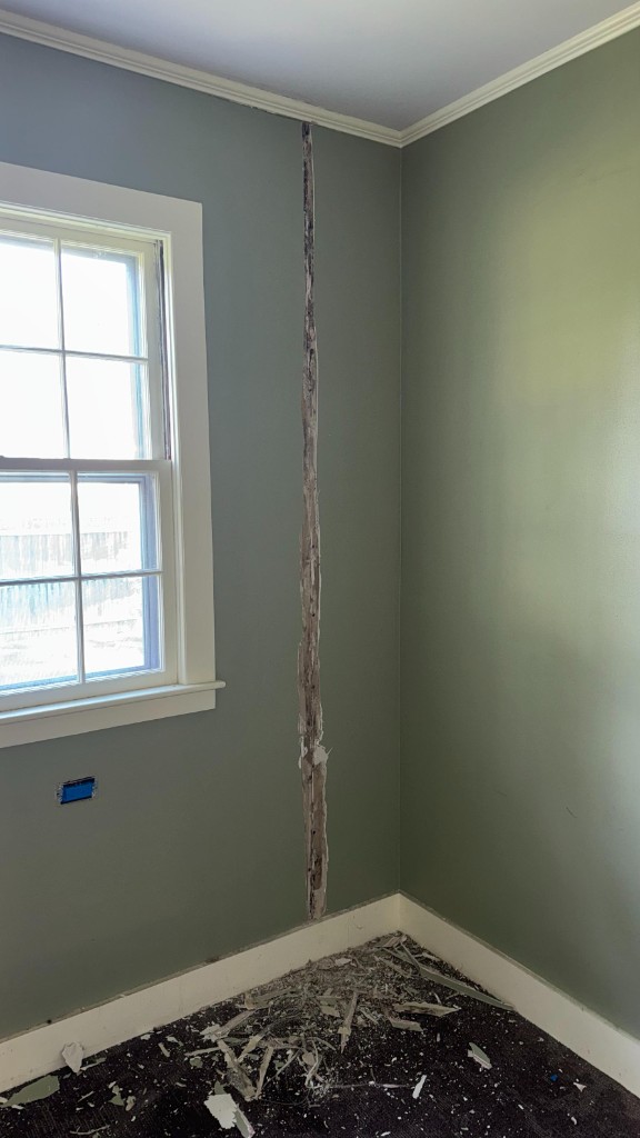 Bedroom corner with torn drywall before repair and painting