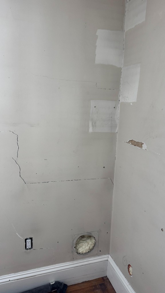 Wall corner with cracks and filler patches before painting