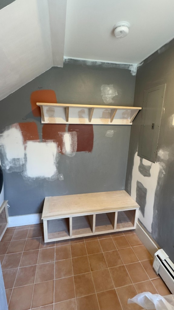 Mudroom bench and walls with paint samples before the finish coat